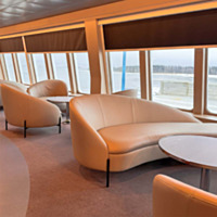 Istuinrivist&ouml; laivalla. Ikkunoista n&auml;kyy merimaisema.