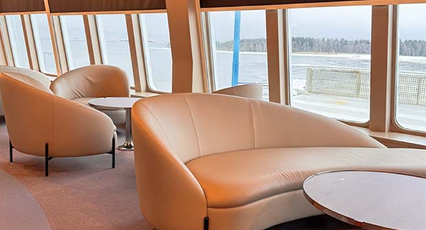 Istuinrivist&ouml; laivalla. Ikkunoista n&auml;kyy merimaisema.