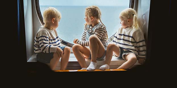 Barn tittar ut över havet i en hytt på Finlandia